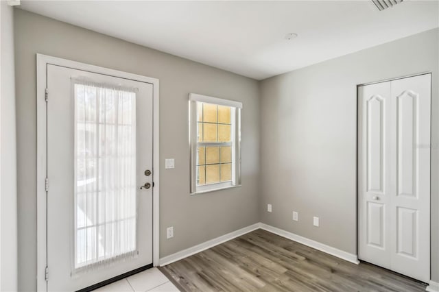 entryway featuring visible vents, baseboards, and wood finished floors