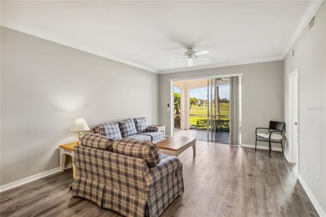 living area featuring wood finished floors, baseboards, and ornamental molding