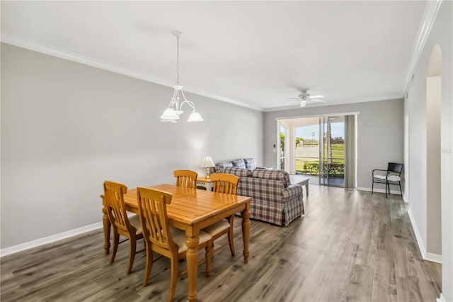 dining area with baseboards, wood finished floors, and crown molding