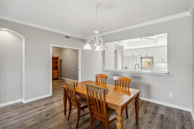 dining area featuring visible vents, baseboards, dark wood-type flooring, and crown molding