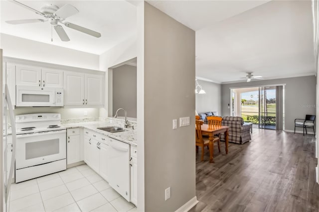 kitchen featuring white appliances, light stone counters, a sink, white cabinetry, and open floor plan