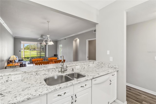 kitchen with light stone countertops, white dishwasher, a sink, white cabinets, and crown molding