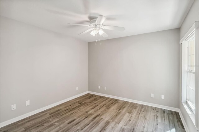 spare room with ceiling fan, baseboards, and wood finished floors