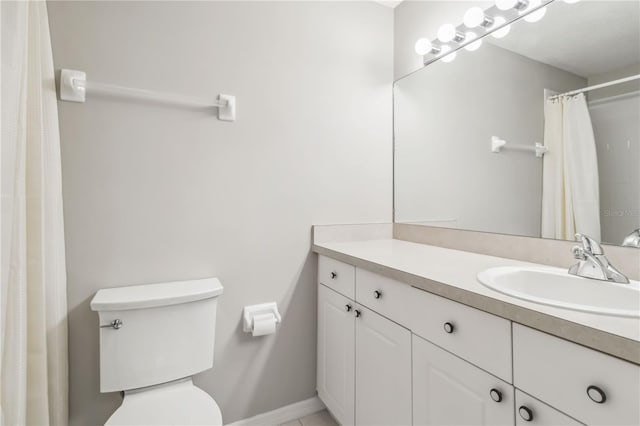 bathroom featuring baseboards, toilet, and vanity