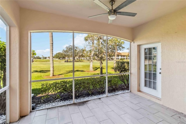 unfurnished sunroom featuring plenty of natural light and ceiling fan