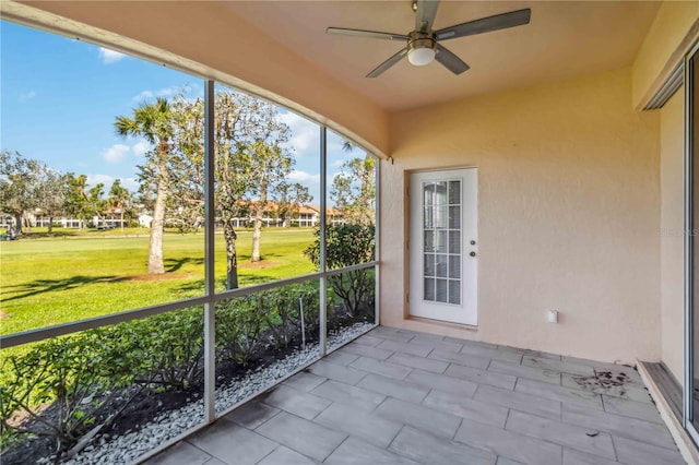 unfurnished sunroom with a ceiling fan