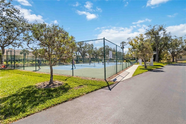 view of sport court featuring a yard and fence