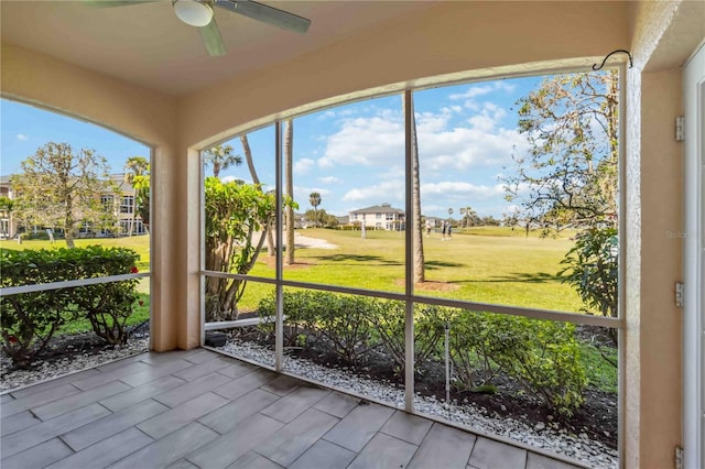 unfurnished sunroom featuring a ceiling fan