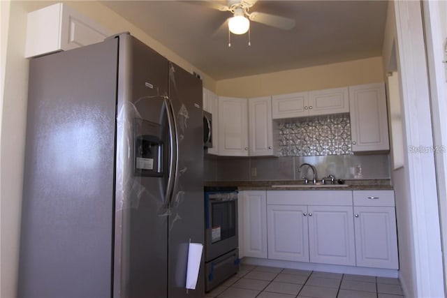 kitchen featuring stainless steel microwave, decorative backsplash, a sink, refrigerator with ice dispenser, and range