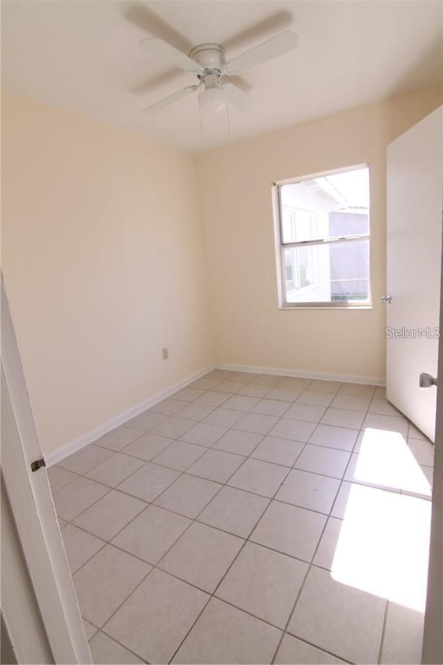 spare room featuring a ceiling fan and baseboards