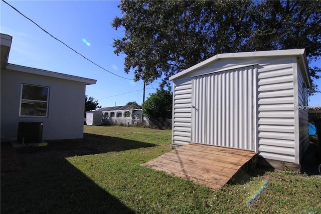 view of yard featuring a storage shed, cooling unit, and an outbuilding