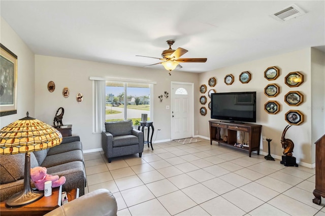 living room featuring light tile patterned floors, baseboards, visible vents, and ceiling fan