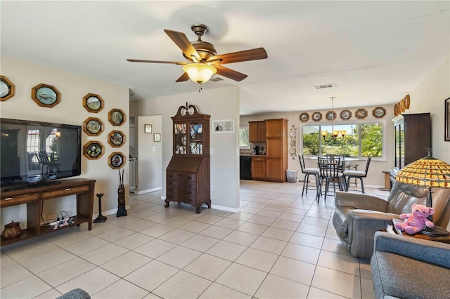 living area featuring light tile patterned floors, visible vents, baseboards, and ceiling fan