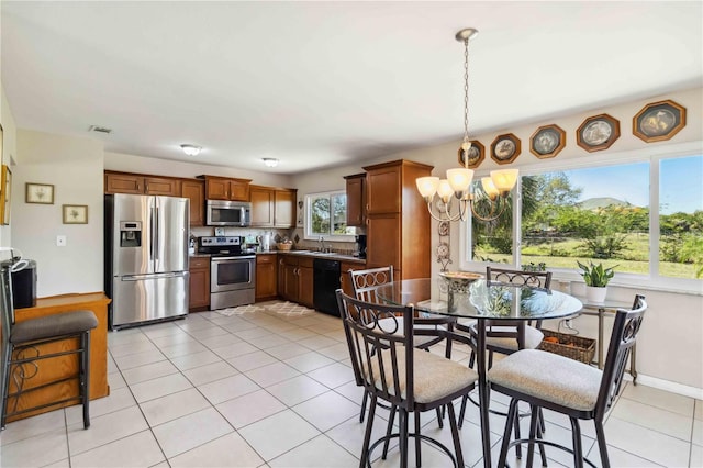 kitchen featuring visible vents, a sink, stainless steel appliances, decorative light fixtures, and a chandelier