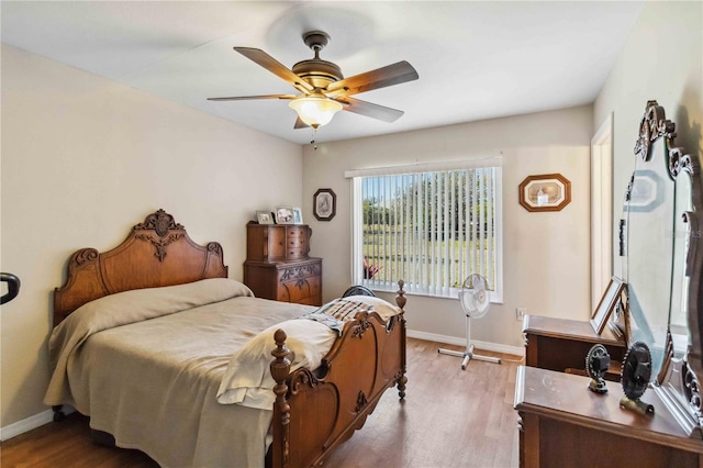 bedroom featuring ceiling fan, baseboards, and wood finished floors