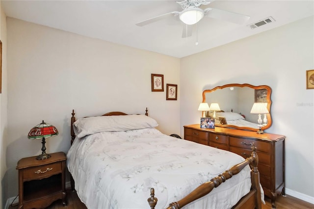 bedroom featuring visible vents, baseboards, a ceiling fan, and wood finished floors