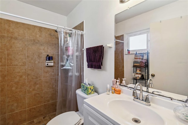 full bath with vanity, toilet, and tiled shower