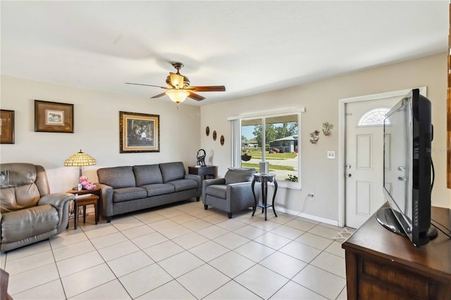 living area featuring light tile patterned floors, baseboards, and a ceiling fan