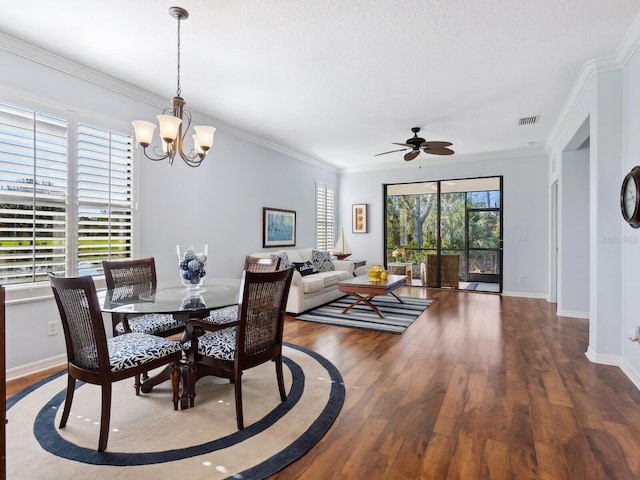 dining space featuring crown molding, visible vents, wood finished floors, baseboards, and ceiling fan with notable chandelier