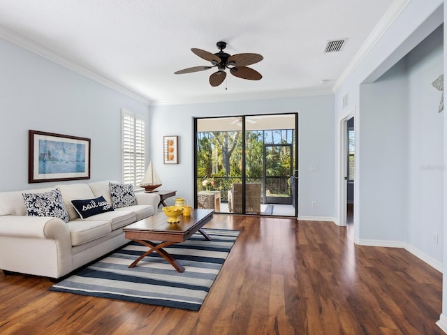 living room with ornamental molding, visible vents, baseboards, and wood finished floors