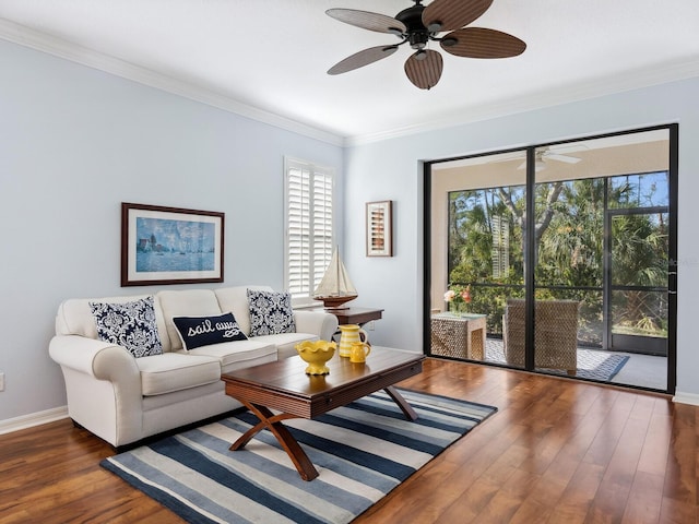 living room with ornamental molding, wood finished floors, a ceiling fan, and baseboards