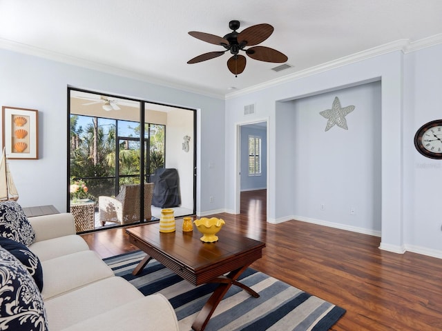 living room with baseboards, crown molding, visible vents, and wood finished floors