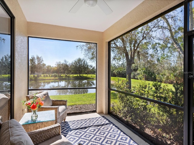 sunroom featuring a water view and a ceiling fan