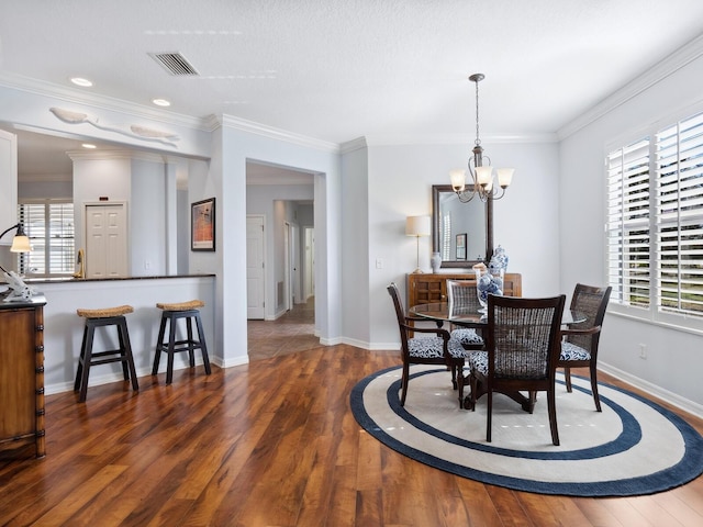 dining room with a wealth of natural light, visible vents, and wood finished floors