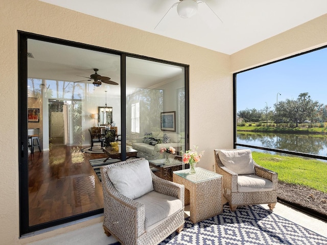 sunroom / solarium with a water view and ceiling fan