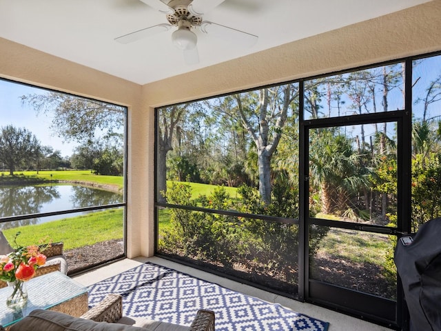 unfurnished sunroom featuring a water view and a ceiling fan