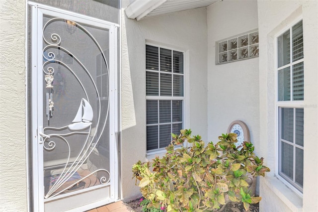 entrance to property featuring stucco siding