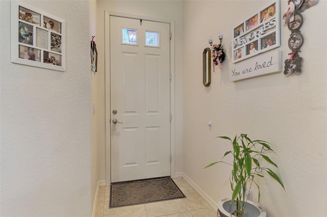 doorway to outside with baseboards and tile patterned floors