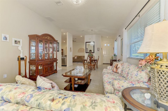 tiled living room featuring a textured ceiling and visible vents