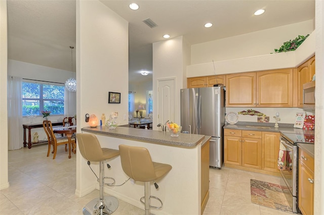 kitchen featuring a breakfast bar area, recessed lighting, visible vents, appliances with stainless steel finishes, and a peninsula