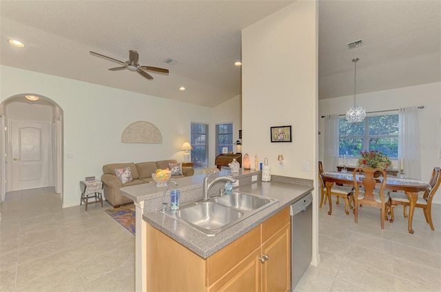 kitchen with arched walkways, a sink, visible vents, open floor plan, and stainless steel dishwasher