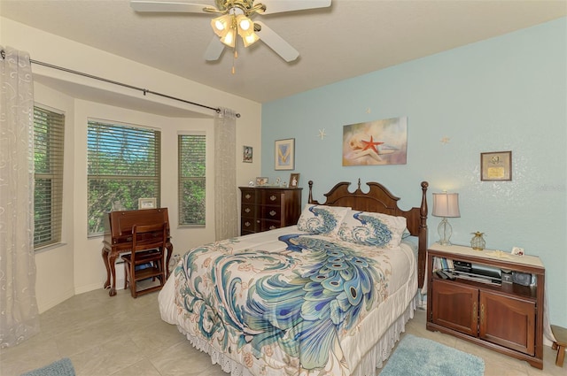 bedroom with light tile patterned flooring, a ceiling fan, and baseboards