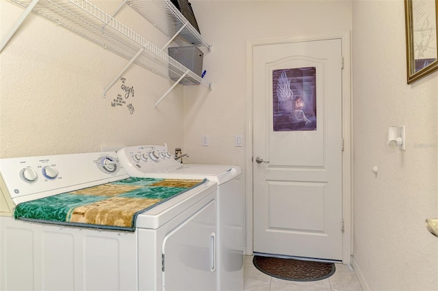 laundry room featuring laundry area, light tile patterned floors, baseboards, and separate washer and dryer