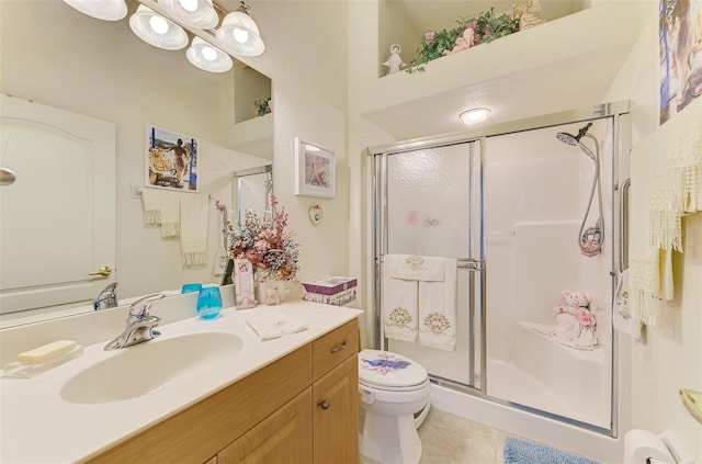 bathroom featuring a stall shower, vanity, toilet, and tile patterned floors