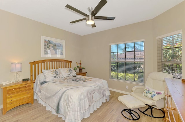 bedroom with a ceiling fan, light wood-type flooring, and baseboards