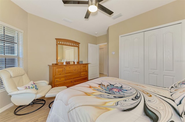 bedroom with visible vents, a ceiling fan, a closet, and wood finished floors