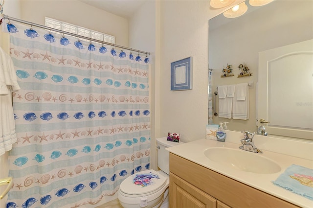 bathroom featuring toilet, curtained shower, and vanity