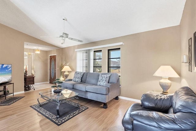 living area with lofted ceiling, ceiling fan, light wood finished floors, and baseboards