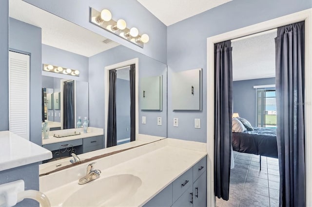 ensuite bathroom with vanity, a textured ceiling, and ensuite bathroom