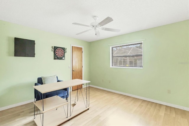 home office featuring ceiling fan, light wood-type flooring, and baseboards