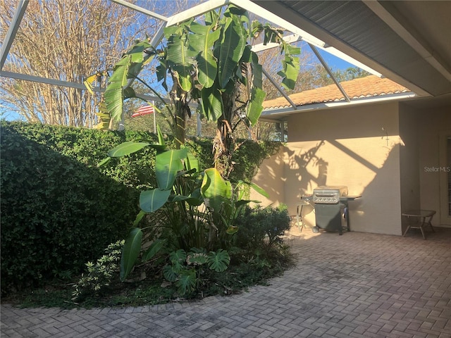 view of side of property with a patio area, a lanai, and stucco siding