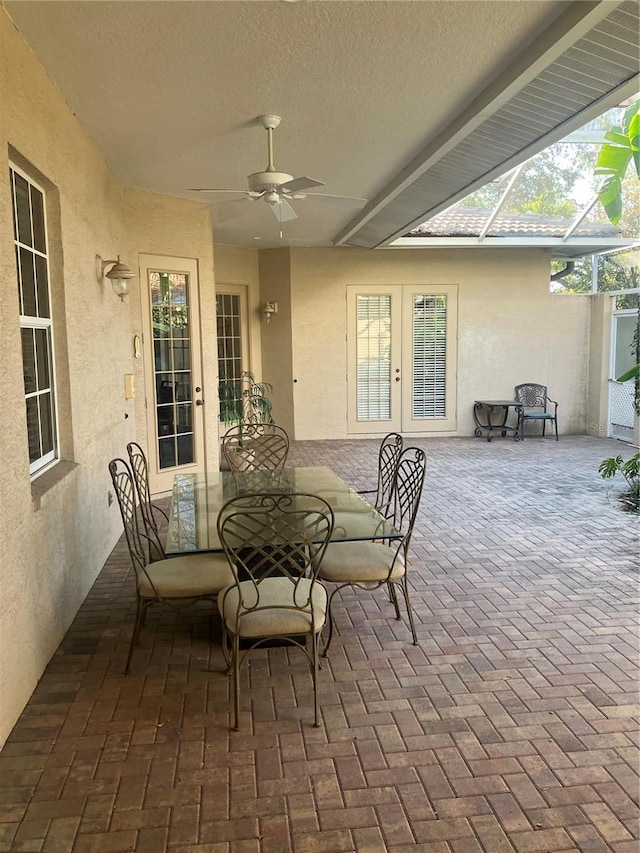 view of patio featuring ceiling fan, french doors, and a lanai