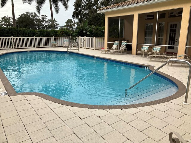 pool with a patio area, fence, and a ceiling fan