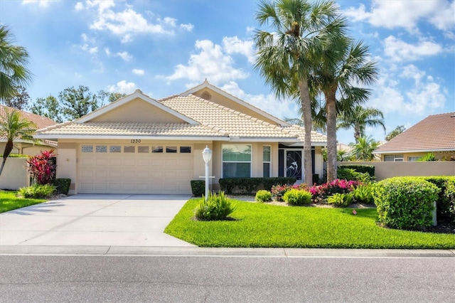 view of front of home featuring a garage, concrete driveway, a tile roof, a front lawn, and stucco siding