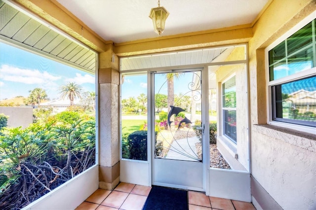 doorway featuring light tile patterned floors and a textured wall