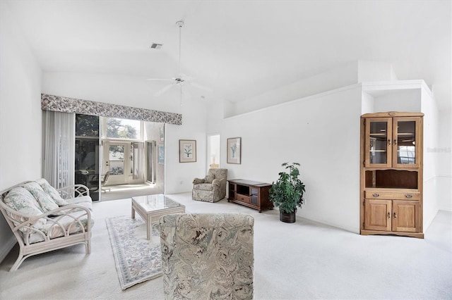 carpeted living room with lofted ceiling, ceiling fan, and visible vents